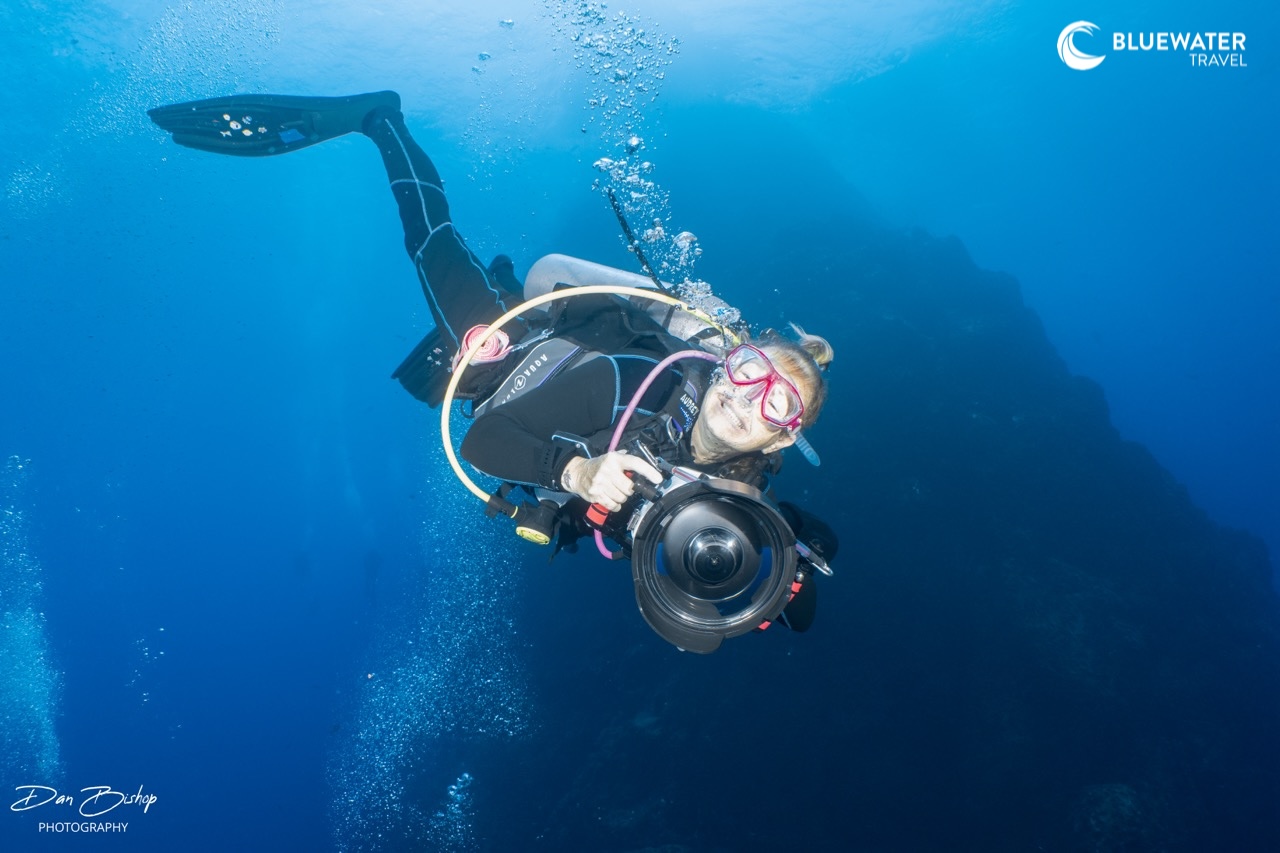 A diver descending with their camera