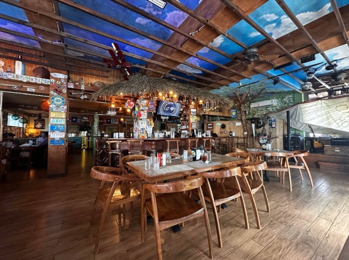 Restaurant interior with a painted sky ceiling.