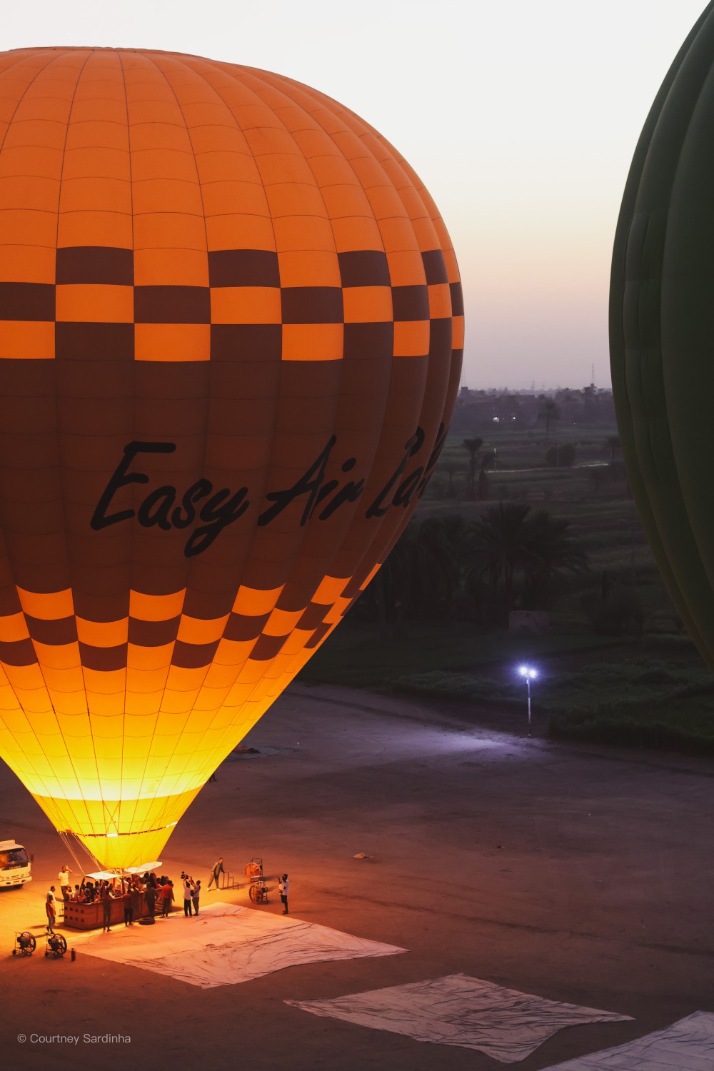 Hot air balloon being inflated on the ground before sunrise in Luxor, Egypt