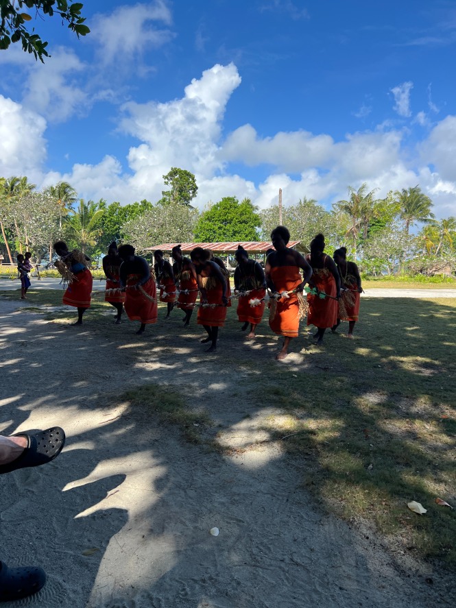 Women in traditional dress performing a welcome dance for visitors